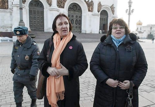 Police escort university professors Yelena Volkova and Irina Karatsuba after detaining them inside the Christ the Saviour Cathedral in Moscow